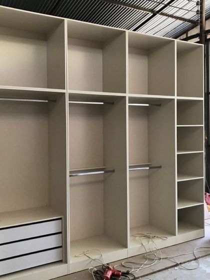 Another view of a large wardrobe unit under construction. This image displays the internal configuration with double hanging sections and multiple compartments, planned for maximum storage capacity before the shutters are installed.