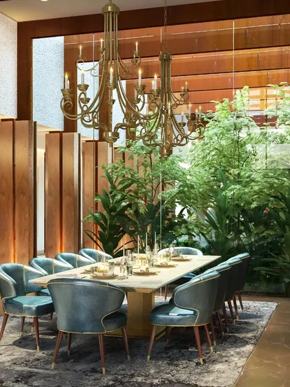 This dining room exemplifies biophilic design, with a lush indoor garden visible through a full-height glass wall. The design brings the calming presence of nature directly to the dining experience.