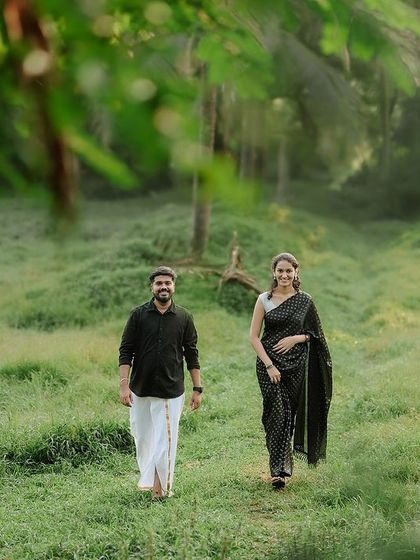 A wide shot of the couple walking through a clearing, framed by trees. This gives a sense of a private, secluded escape.