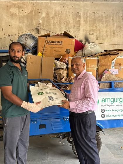 Our team member receives a bag of collected dry waste from a Mayfield Gardens resident, ready to transport it to our Samadhaan Hub for recycling.