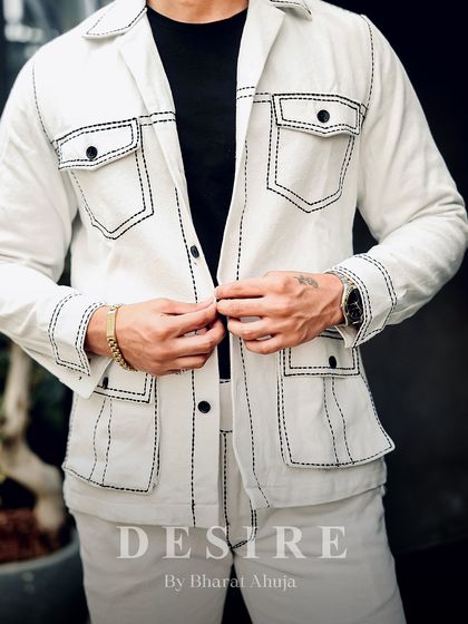 Buttoning up the all-white jacket, this shot shows the full set of utility pockets and the impeccable tailoring that defines this modern co-ord set.