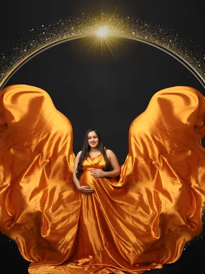 Framed in a circle of light, this mom-to-be looks majestic in a golden gown with fabric tossed to look like wings. A truly celestial portrait.