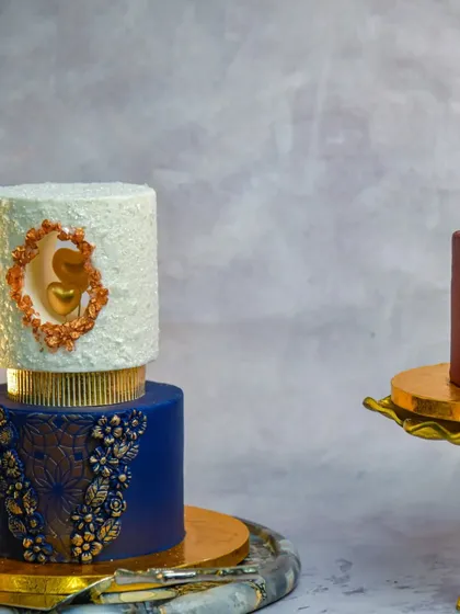 Another example of our modern cake art. This design features a royal blue tier with gold lace and a white textured tier with a heart window.