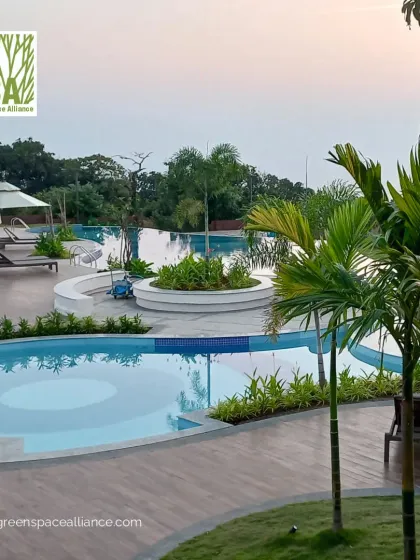 This resort-style pool deck features multiple interconnected pools, comfortable lounge seating, and lush tropical planting. Our design creates a luxurious and relaxing environment, perfect for a holiday home township or a high-end residential club.