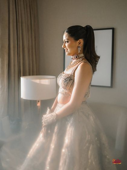A dreamy, light-filled portrait of the bride for her Sangeet. The high ponytail and glowing makeup give her a princess-like aura.