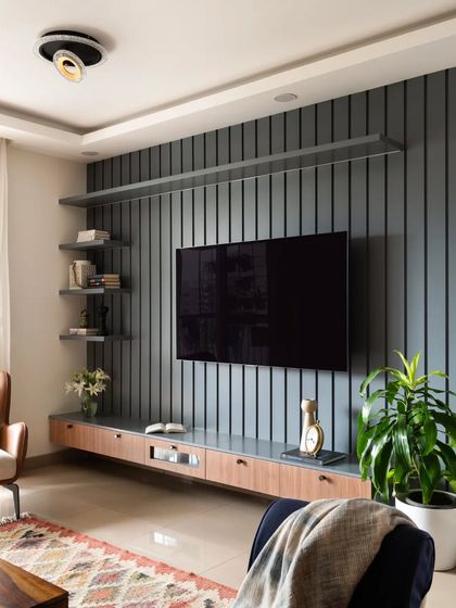A wider view of the grey TV unit, showcasing the floating shelves that provide ample space for books and decor.