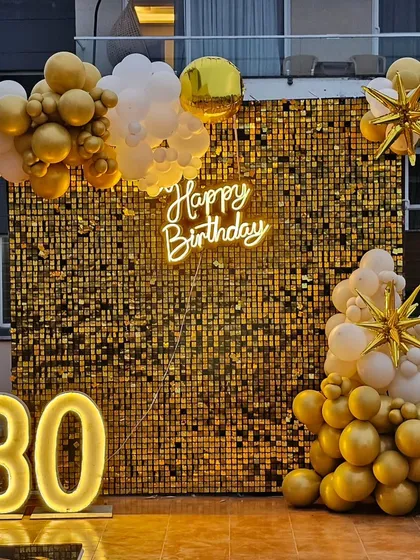 A glamorous 30th birthday setup featuring a full gold sequin shimmer wall, a custom 'Happy Birthday' neon sign, and large light-up marquee numbers. This is one of our most popular backdrops for photos.