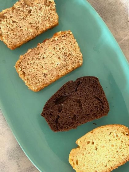 A tasting platter of four different tea cake slices, showcasing the variety I offer. You can see the different textures and colours, from a dark chocolate loaf to a classic vanilla.