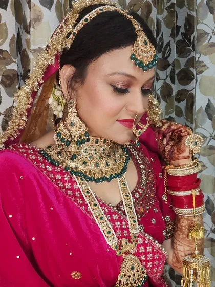 This image showcases the complete look, including the intricate henna and the way the makeup ties in with the colors of the lehenga and jewelry.