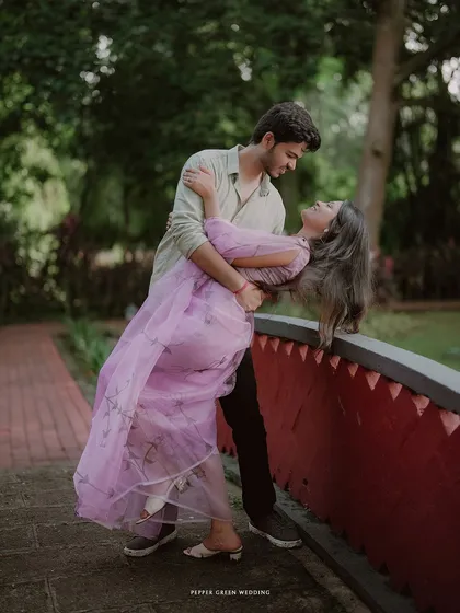 A graceful dance on a small bridge. This pre-wedding photo captures a moment of classic romance and movement.