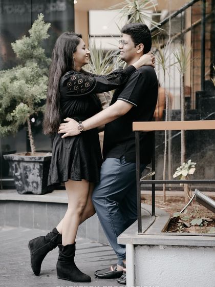 An affectionate embrace outside a cafe, showcasing the couple's connection in a modern, urban setting.