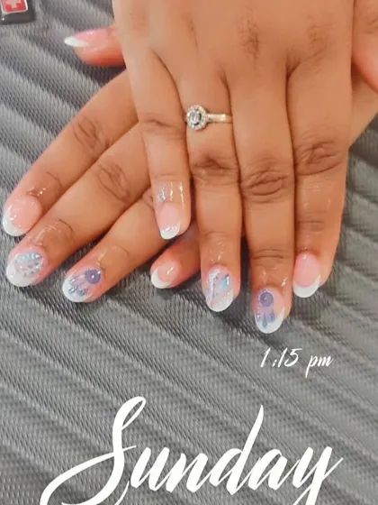 This is another lovely option for an engagement. It's a French manicure with a twist, featuring delicate floral art and glitter on the accent nails to draw attention to the ring.
