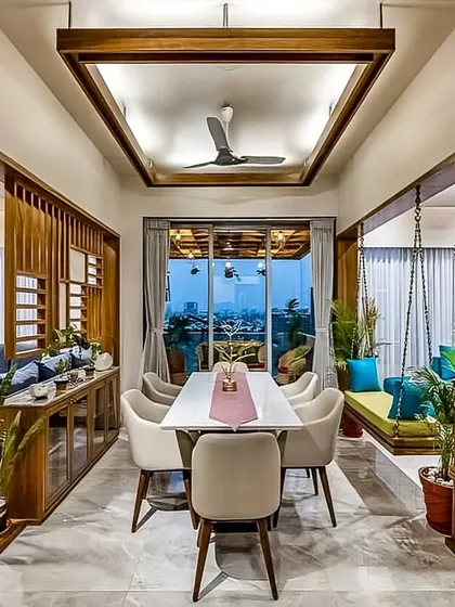 This open-plan living and dining area showcases our ability to create cohesive, multi-functional spaces. The design uses wood partitions and a traditional swing to define zones, while maintaining a spacious and airy feel with a view of the city.