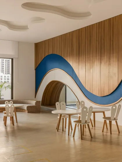At Vedanya School, we used gentle curves and flowing lines to create a learning environment free from rigid boundaries. This classroom, with its wavy wooden feature wall and integrated reading nook, invites exploration and nurtures a deep connection between the students and their environment.
