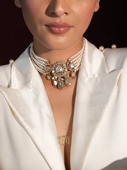 This exquisite polki and pearl choker is the epitome of royal elegance. Paired with a modern outfit like this white blazer, it creates a powerful Indo-western look that is perfect for a welcome dinner or reception.