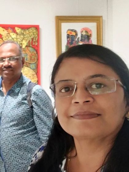 A selfie taken at the art exhibition, with my husband in the background enjoying the art.