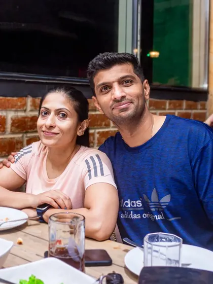A couple enjoying a meal and drinks at a cozy table.