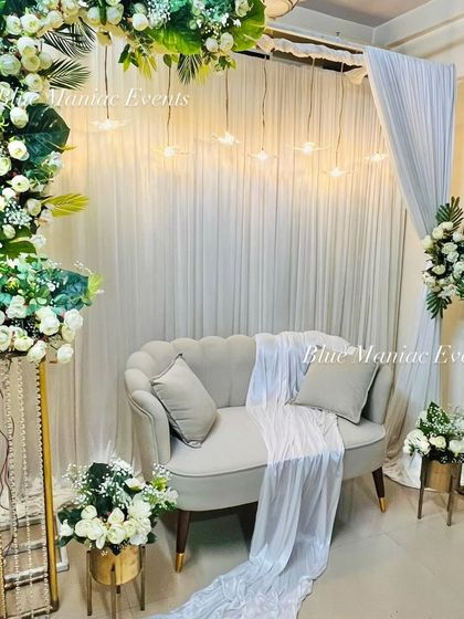 A different angle of the C-shaped arch Roka setup, showing the depth and layering of the floral arrangements and the soft glow of the hanging lights.