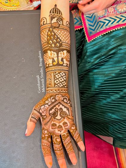 A stunning design for a bride from Rome, featuring peacocks, elephants, and palace architecture.