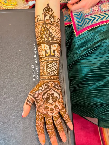 A stunning design for a bride from Rome, featuring peacocks, elephants, and palace architecture.