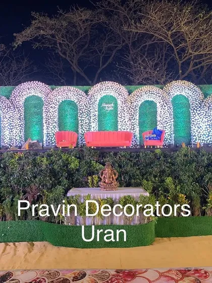 This reception stage was designed to blend with the natural surroundings. We used a series of green arches covered in white flowers, set against a backdrop of real trees, to create a beautiful and organic open-air setting.
