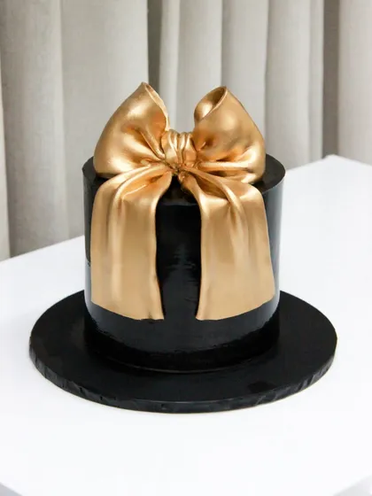 My take on the trending big bow cake, this time in a chic black and gold combination for a sophisticated birthday celebration.