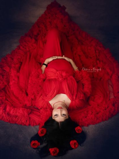 A creative overhead shot where the red gown is arranged to look like a giant heart. This is a unique and artistic way to capture your pregnancy.