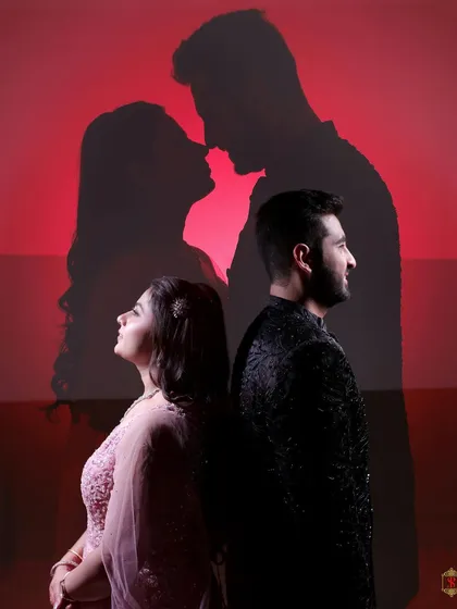 A powerful silhouette shot of the couple overlaid on their portrait against a striking red background.