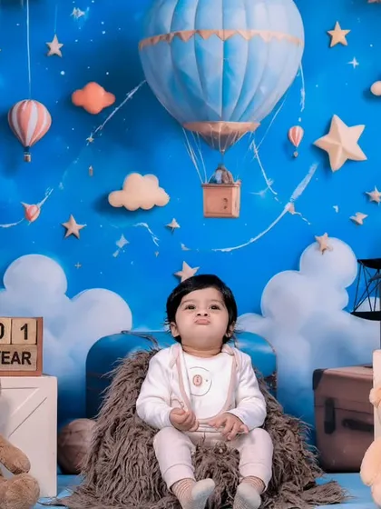 A one-year-old baby girl looking regal in her chair during the teddy bear travel-themed shoot.