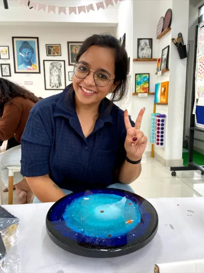 A participant gives a peace sign, happy with her finished galaxy resin clock.