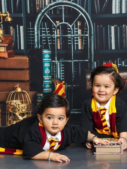 One twin crawls towards a new adventure while the other smiles brightly. This dynamic shot shows the fun and energy of a twin Harry Potter session.