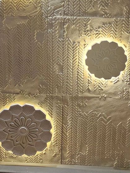 A feature wall panel with a metallic gold finish and backlit floral medallions. This design blends traditional patterns with modern lighting technology.