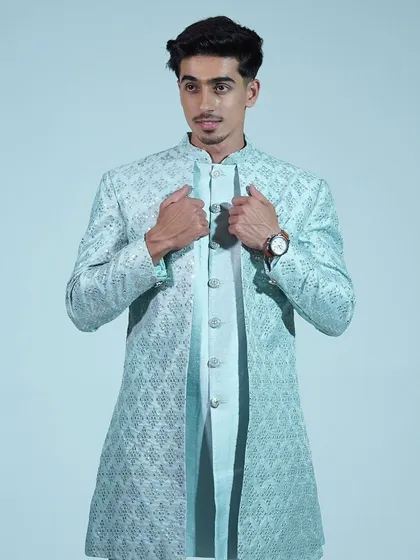 A close-up of the light blue sherwani, showing the intricate embroidery and elegant design.