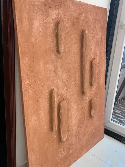 The 3ft x 4ft terracotta-colored textured piece before installation. The raised forms are inspired by natural desert landscapes.