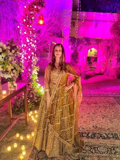 Another shot of our client in the golden-brown lehenga, this time under dramatic pink lighting. The outfit looks stunning in every light.