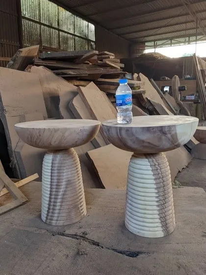 A pair of unfinished, ribbed side tables.
