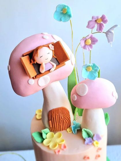 A close-up of the sleeping fairy in the mushroom house topper.