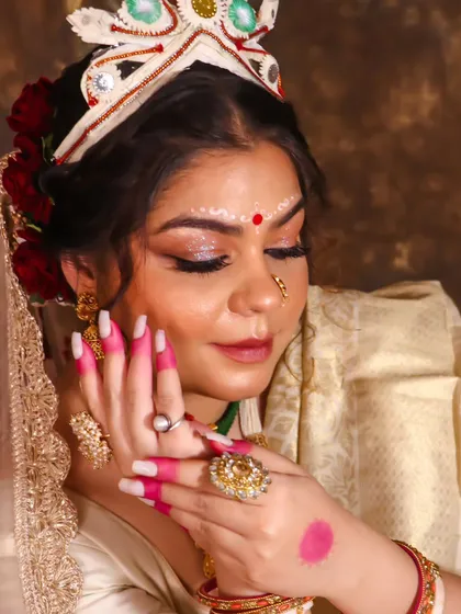 This Bengali bridal look is all about the details, from the alta on her hands to the delicate chandan design on her forehead. The makeup is designed to look flawless, even without filters.
