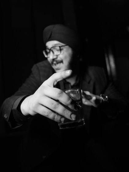 A candid black and white shot of a guest enjoying a drink. It's these small, atmospheric moments that help to tell the complete story of the wedding night.
