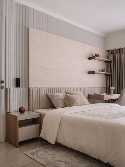 The father's bedroom is a serene space with fluted walls, a custom headboard, and integrated bedside tables for a clean, uncluttered look.