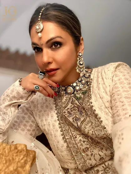 A portrait of regal charm. Isha Koppikar Narang showcases the intricate details of the heavy Polki choker and chandelier earrings, a set designed for the most magnificent occasions.