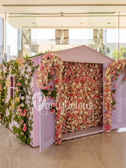 A breathtaking floral house photo booth, completely covered in pink and white roses, creating a fairytale moment.