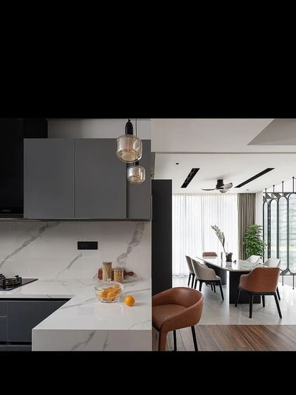 The open-plan layout connects the kitchen to the dining area, which is defined by a set of elegant, rotating screens.