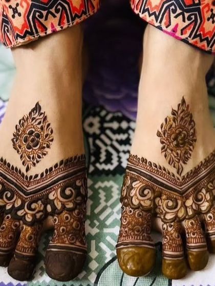 A simple and traditional design for the feet. The pattern covers the toes with intricate details and features a single, elegant buti on the top of the foot.