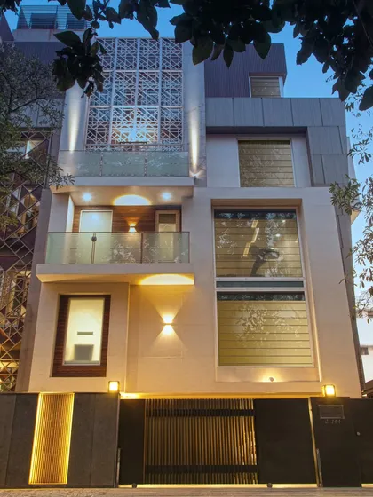 From sketch to structure, this facade tells a story of vision and seamless execution. The strategic use of architectural lighting highlights the intricate trellis work, textured stone, and clean lines, transforming the building into a beacon of modern design at dusk.