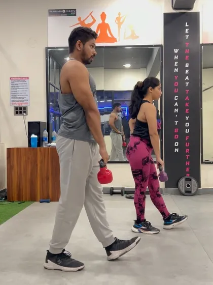 This image shows a single-leg deadlift with a kettlebell, a key exercise in our leg workouts for improving balance and hamstring strength.