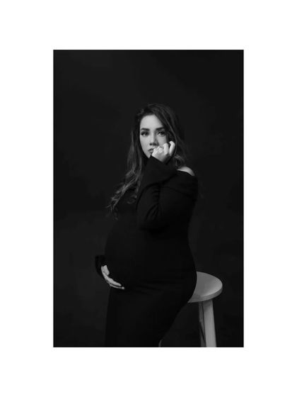 A pensive and beautiful black and white portrait. The low-key lighting and the subject's thoughtful expression create a moody and intimate atmosphere.