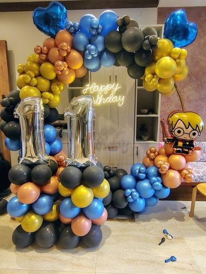 Accio party! I brought the magic of Hogwarts to this Harry Potter themed 11th birthday. The balloon arrangement used the colors of the Hogwarts houses, complete with a Harry Potter balloon figure and silver foil number '11' balloons.