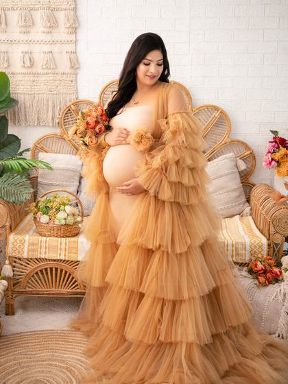 Earthy, warm, and radiant. This mother-to-be is styled in a layered tulle gown in a beautiful ochre tone, perfectly complementing the natural textures of our boho studio set.