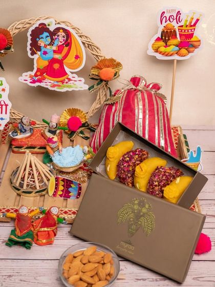 This beautiful Holi hamper features a box of my signature fusion gujiyas, almonds, and other treats, all decorated with cute Radha-Krishna and Holika Dahan cutouts.